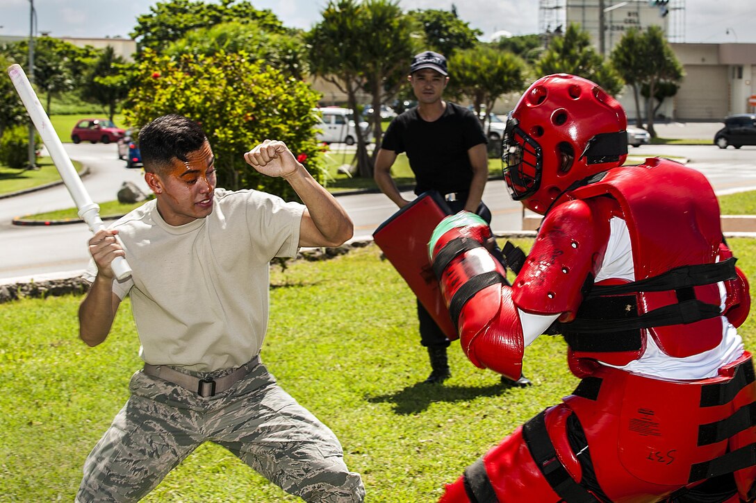 Air Force Airman Joshua Lenaire uses a training baton to subdue an attacker in a red-man suit after being sprayed with OC spray, also known as pepper spray, during training at Kadena Air Base, Japan, July 13, 2016. Lenaire is a response force member assigned to the 18th Security Forces Squadron. Air Force photo by Airman 1st Class Corey M. Pettis