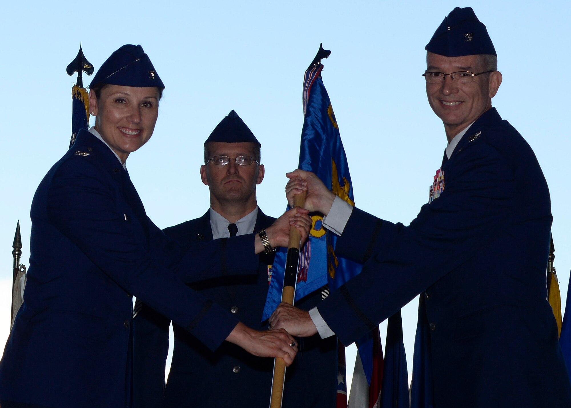 Col. April Vogel, commander of the 6th Air Mobility Wing, passes the 6th Medical Group (MDG) guidon to the incoming group commander, Col. Kevin Wright, during a change of command ceremony at MacDill Air Force Base, Fla., July 15, 2016. The ceremony marks the beginning of Wright’s tenure as the 6th MDG commander. (U.S. Air Force photo by Tech. Sgt. Krystie Martinez)