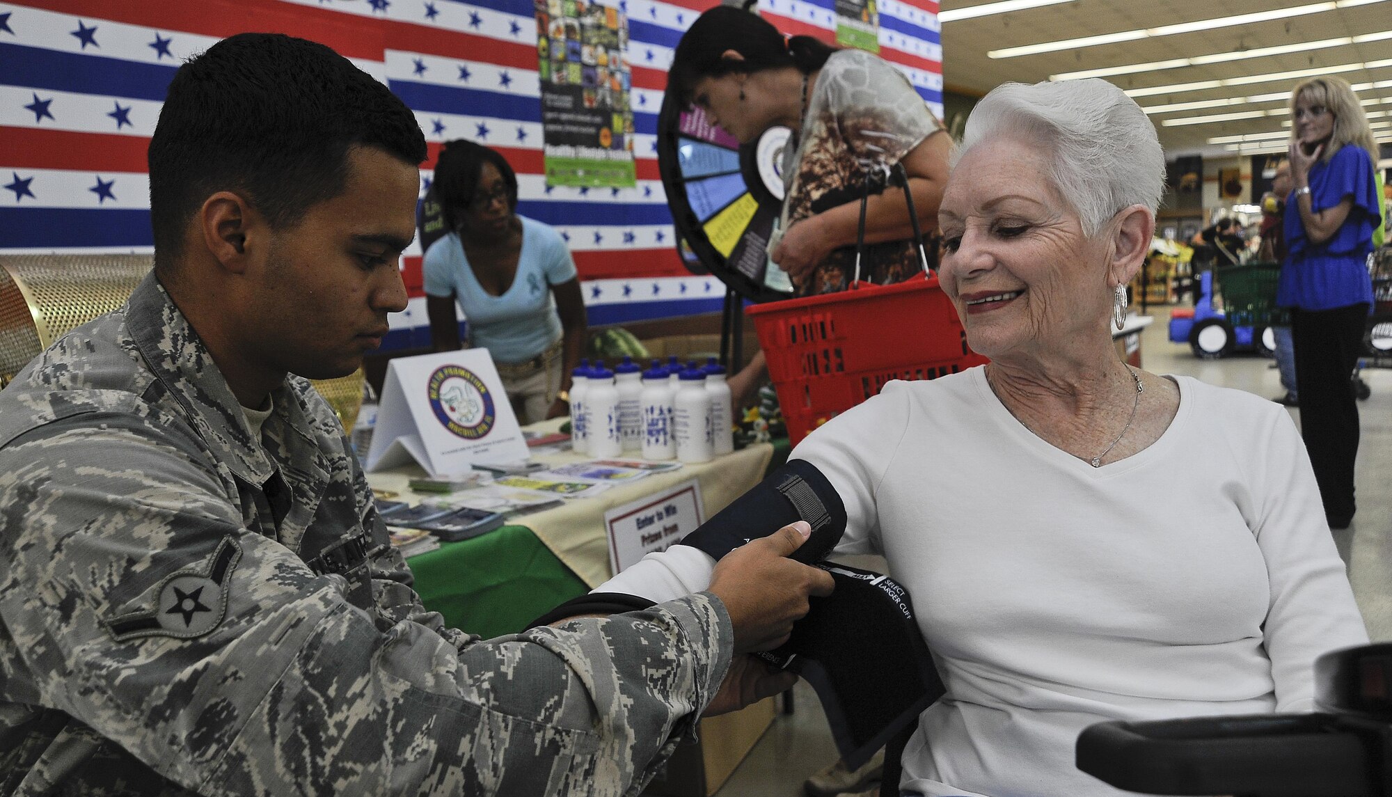 An Airman takes a commissary shopper’s blood pressure during the Healthy Lifestyle Festival at MacDill Air Force Base, Fla., July 15, 2016. The theme of the event was “Shop healthy, eat healthy and be healthy.” (U.S. Air Force photo by Airman 1st class Mariette Adams)