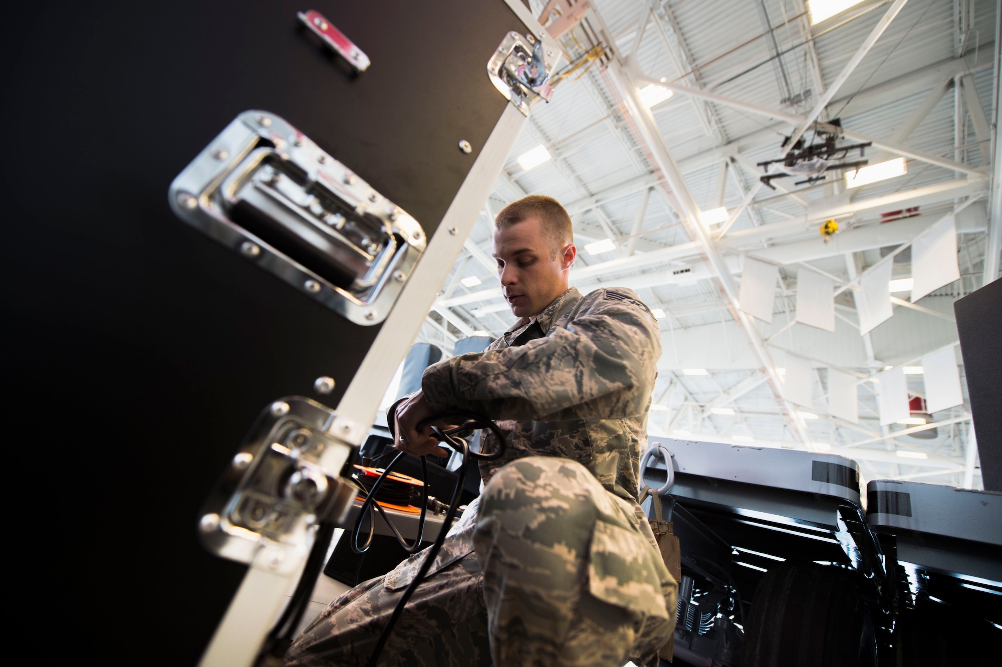 Staff Sgt. Andrew Muhlhahn, a radio frequency systems journeyman with the 1st Special Operations Communications Squadron, sets up audio equipment for a change of command ceremony at the Freedom Hangar on Hurlburt Field, Fla., July 15, 2016 Airmen from the 1st SOCS are charged with an additional duty to setup audio systems for public address at base functions. (U.S. Air Force photo by Senior Airman Krystal M. Garrett)
