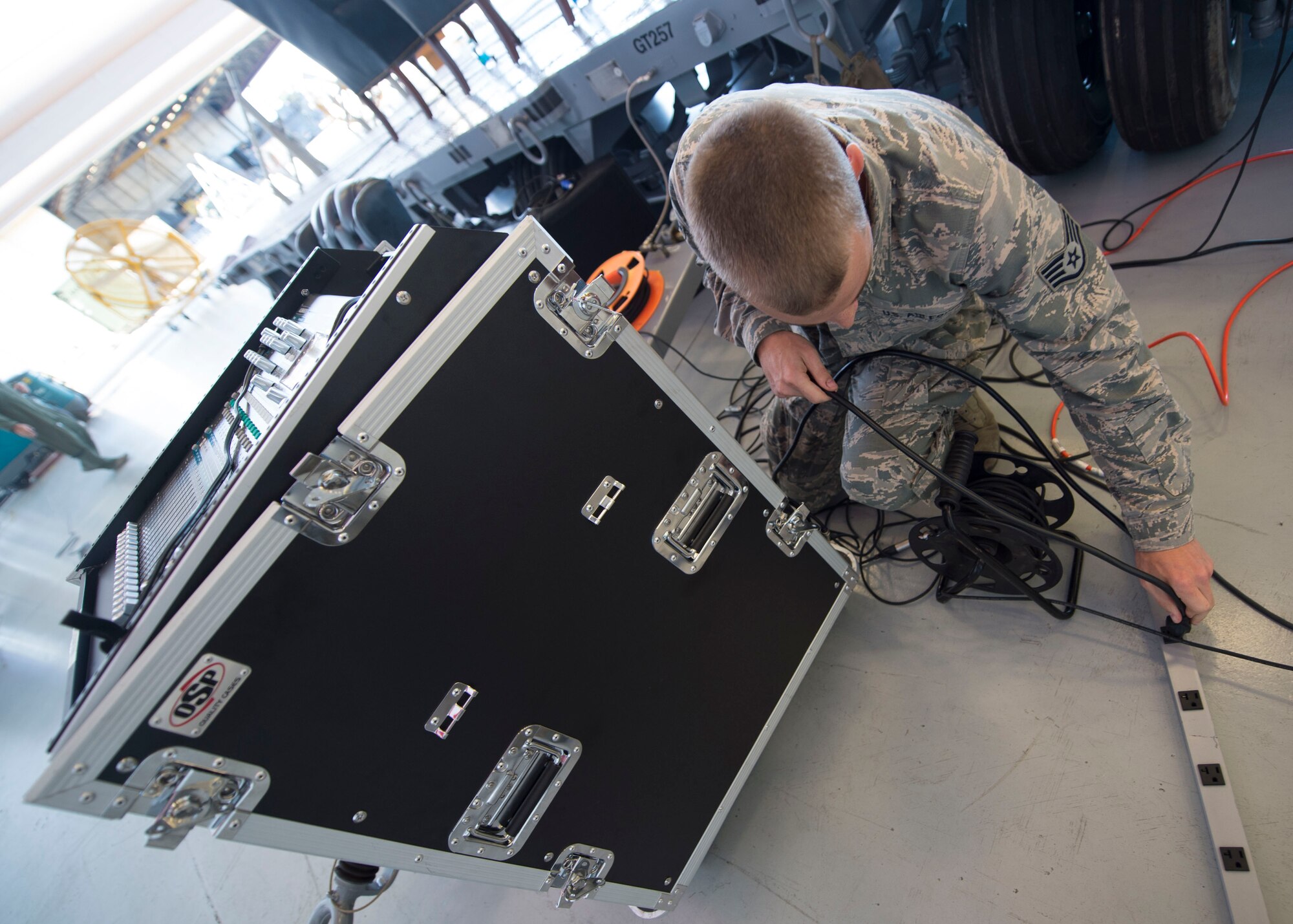Staff Sgt. Andrew Muhlhahn, a radio frequency systems journeyman with the 1st Special Operations Communications Squadron, sets up audio equipment for a change of command ceremony at the Freedom Hangar on Hurlburt Field, Fla., July 15, 2016. 1st SOCS Airmen provide audio support for different ceremonies and events on base. (U.S. Air Force photo by Senior Airman Krystal M. Garrett)