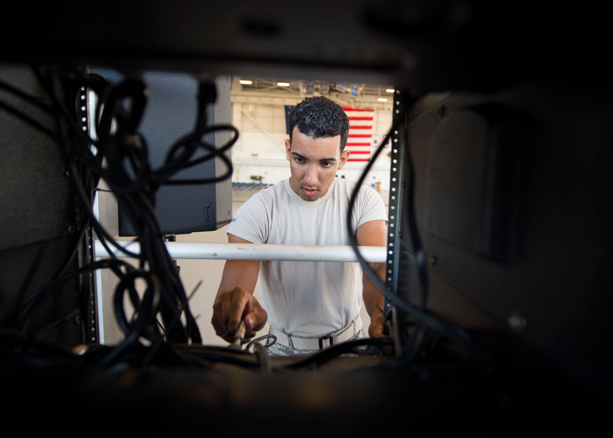 Airman 1st Class Sean Ludwig, a radio frequency systems apprentice with the 1st Special Operations Communications Squadron, sets up a mixer and power amplifier box for a change of command ceremony at the Freedom Hangar on Hurlburt Field, Fla., July 15, 2016. 1st SOCS Airmen provide audio support for different ceremonies and events on base. (U.S. Air Force photo by Senior Airman Krystal M. Garrett)