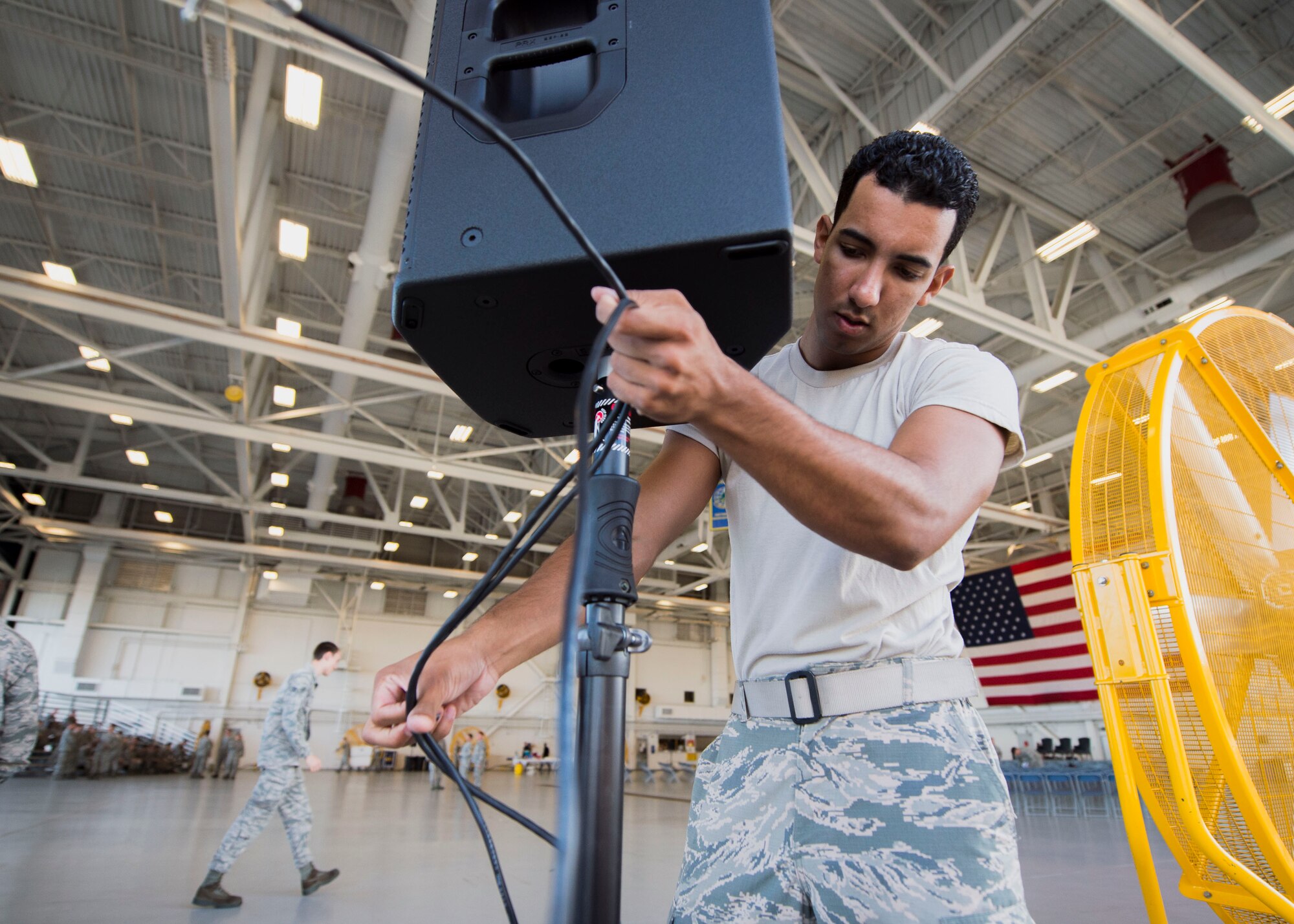 Airman 1st Class Sean Ludwig, a radio frequency systems apprentice with the 1st Special Operations Communications Squadron, sets up a speaker for a change of command ceremony at the Freedom Hangar on Hurlburt Field, Fla., July 15, 2016. 1st SOCS Airmen provide audio support for different ceremonies and events on base. (U.S. Air Force photo by Senior Airman Krystal M. Garrett)