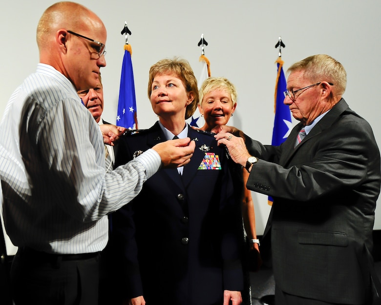 Lt. Gen. Maryanne Miller receives her new rank devices from family members during a promotion ceremony at the Museum of Aviation in Warner Robins, Ga. Miller is the Air Force Reserve's first female Lieutenant General and the first female Chief of the Air Force Reserve. (U.S. Air Force photo by Matthew A. Ebarb/Released)