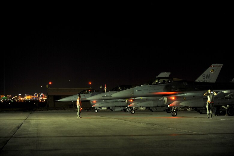 Maintainers from the 20th Aircraft Maintenance Squadron, Shaw Air Force Base, S.C., marshal F-16 CJs into position prior to a Red Flag 16-3 night training mission July 13, 2016 at Nellis AFB, Nev. Night missions play a crucial role in Red Flag exercises, allowing aircrews and maintainers the opportunity to test their skills in challenging low-light conditions. (U.S. Air Force photo by Senior Airman Joshua Kleinholz/Released)
