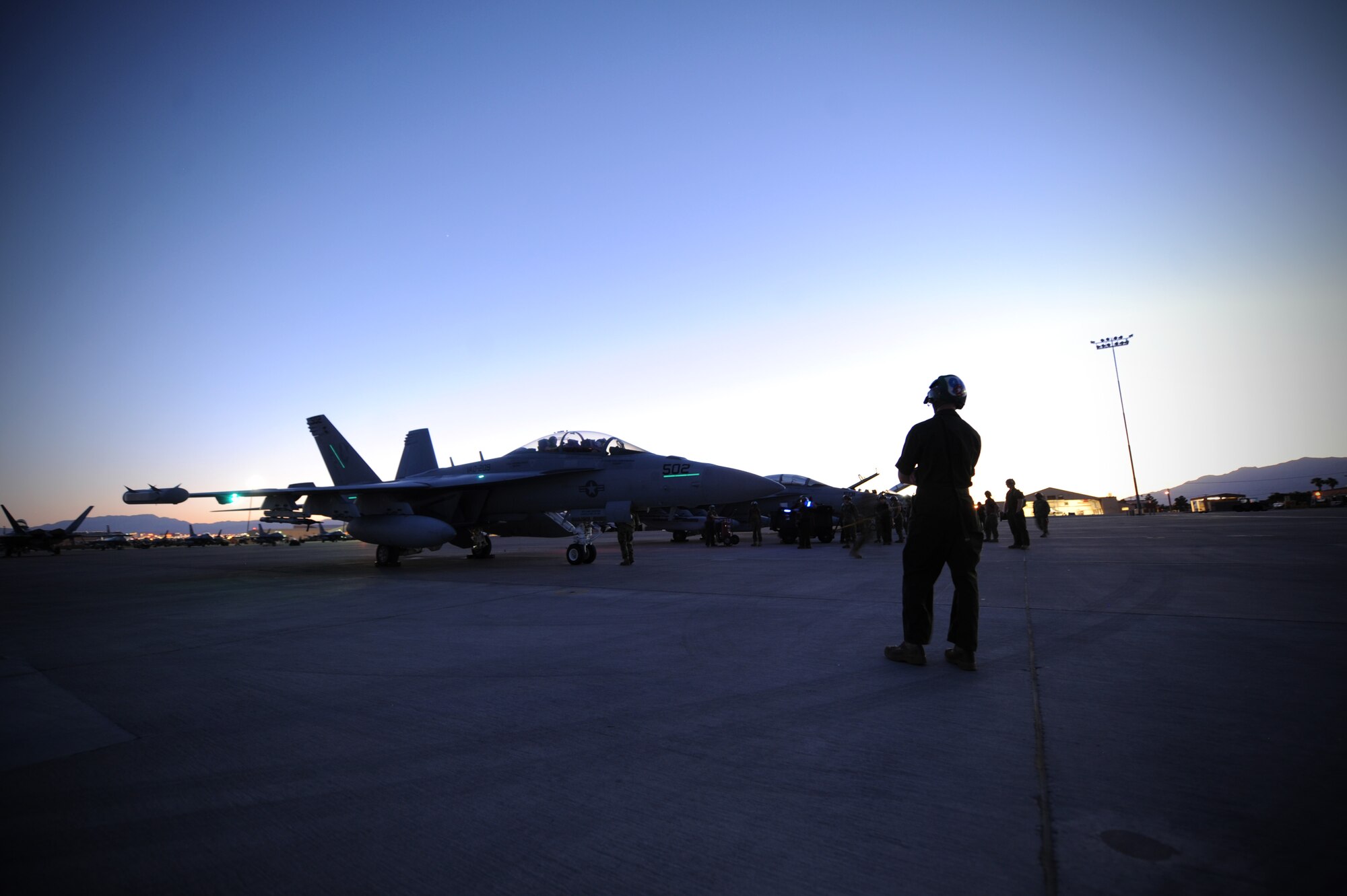 Maintainers assigned to Electronic Attack Squadron-209, EA-18G, NAS Whidbey Island, Washington, standby to recover and assist the aircrew of an EA-18G Growler after completion of a Red Flag 16-3 training sortie July 13, 2016 at Nellis AFB, Nev. A variant of the combat-proven F/A-18F Super Hornet, the Growler provides tactical jamming and electronic protection to U.S. military forces and allies around the world.  (U.S. Air Force photo by Senior Airman Joshua Kleinholz/Released)
