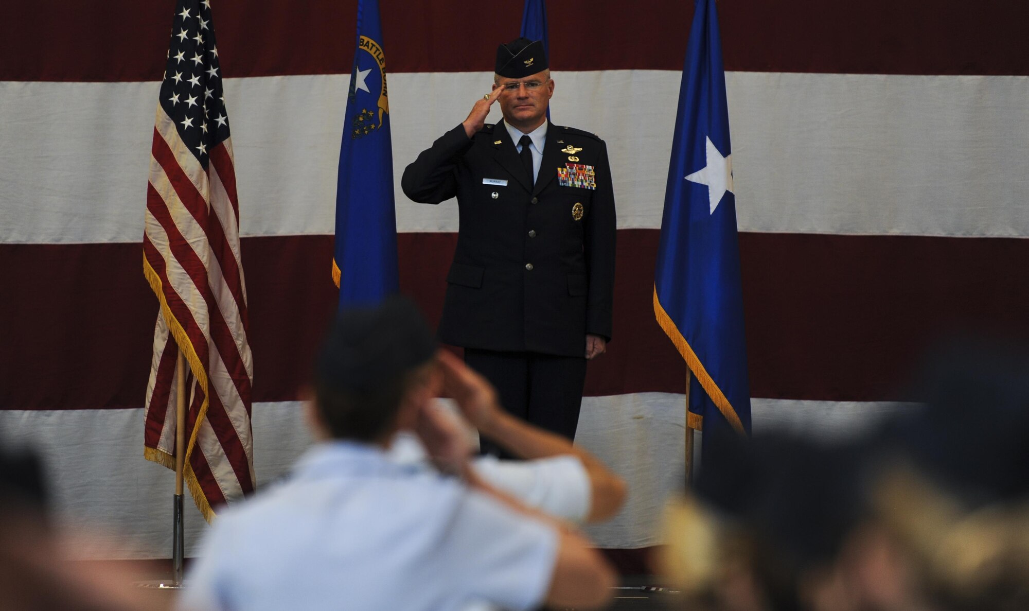 Col. Paul Murray receives his first salute as commander of the 99th Air Base Wing during a change of command ceremony held inside the Strike Aircraft Maintenance Unit hangar at Nellis Air Force Base, Nev., July 15, 2016. Murray expressed his pride and humility for the chance to be commander of the 99th ABW. (U.S. Air Force photo by Airman 1st Class Kevin Tanenbaum)