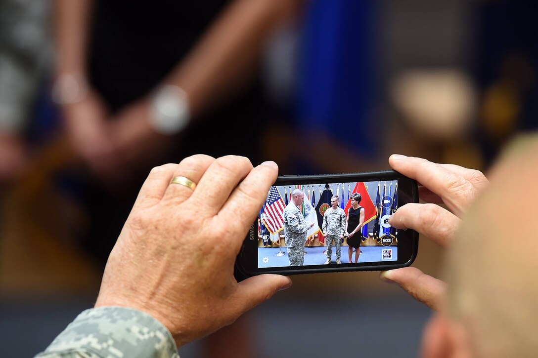 Command Sgt. Maj. Michael Goodwin, Command Sergeant Major, 2nd Mobilization Support Group, takes a photo of the 2nd MSG's outgoing commander Col. Walter C. Catlett at an award ceremony for him following the 2nd MSG's change of command, July 9, 2016.
 (Photo by Sgt. First Class Anthony L. Taylor)