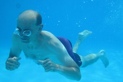 Sgt. First Class Joel Johnson, Assistant to the Command Sergeant Major, 85th Support Command, swims underwater after diving into a pool, at Pioneer Park in Arlington Heights, Illinois, during the 85th Support Command's family day event on July 10, 2016.
 (Photo by Sgt. Aaron Berogan)