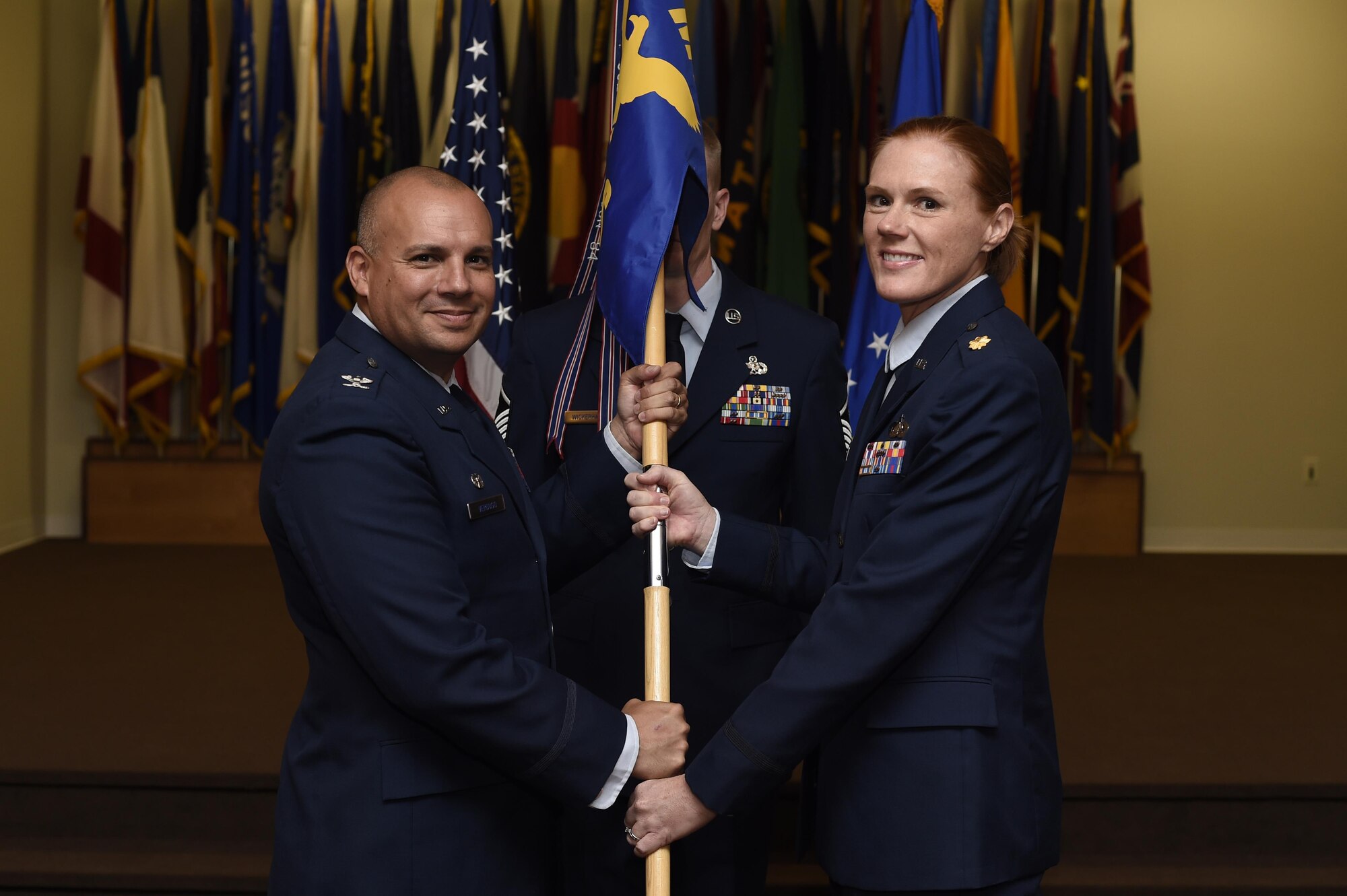 Col. Frank Verdugo, 90th Mission Support Group Commander, passes the guidon to Maj. Shannon Hughes, 90th Force Support Squadron commander, during the 90th FSS change-of-command ceremony at F.E. Warren Air Force Base, Wyo., July 15, 2016. The ceremony signified the transition of command from Lt. Col. David Olinger. (U.S. Air Force photo by Staff Sgt. Christopher Ruano)