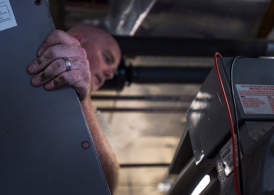 Staff Sgt. Ben Levalley, 11th Civil Engineer Squadron HVAC journeyman, repairs an air conditioning unit at the Child Development Center Three on Joint Base Andrews, Md., July 13, 2016. The HVAC flight cares for approximately 2,400 air conditioning systems throughout JBA. (U.S. Air Force photo by Senior Airman Mariah Haddenham)