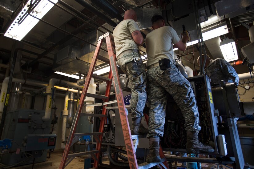 Airmen from the 11th Civil Engineer Squadron on Joint Base Andrews, Md., July 13, repair an air conditioning unit at the Child Development Center Three on Joint Base Andrews, Md., July 13, 2016. The HVAC flight cares for approximately 2,400 air conditioning units throughout JBA. (U.S. Air Force photo by Senior Airman Mariah Haddenham)