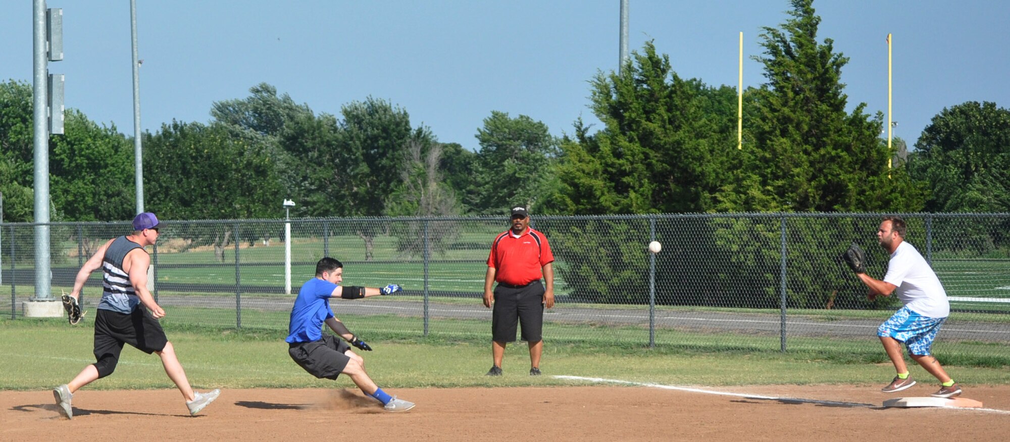 160715-F-JJ999-001 Clayton “Bacon” Coover, left, with the 551st CMMXS, and Leslie Wood attempt to run down Thunderhawk David Theophilos between first and second base July 7. After a few throws, Theophilos was tagged out. The Thunderhawks won the intramural softball game 19-11. (Air Force photo by John Parker)