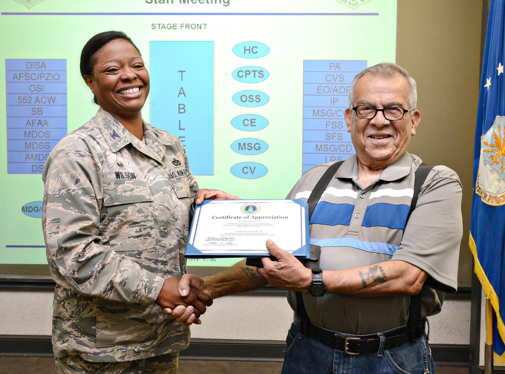 72nd Air Base Wing Commander Col. Stephanie Wilson presents retired Chief Master Sgt. Jesse Guiterrez with a certificate/award for the 2015 Retiree Volunteer of the Year Commendation. Chief Guiterrez has volunteered in the Tinker Clinic pharmacy for over 20 years. (Air Force photo by Kelly White)