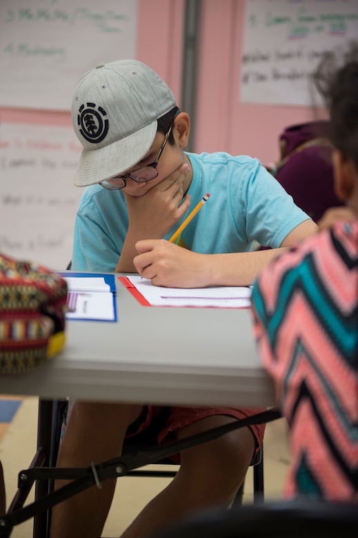 Andre Perez, a participant of the first resiliency teen camp, named BOUNCE, writes in his folder July 14, 2016 at Joint Base Charleston – Weapons station, S.C., youth center. BOUNCE, which stands for Be optimistic, Observe thoughts, Use strengths, Never give up, Communicate effectively and Embrace you, is a week-long camp designed to teach teens the necessary skills to overcome daily stressors associated to military families. (U.S. Air Force photo/Staff Sgt. Jared Trimarchi)