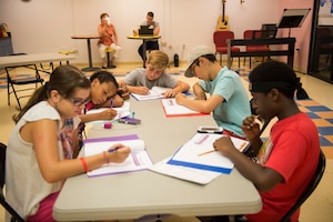 Participants of the first Air Force resiliency teen camp, named BOUNCE, write in their folders July 14, 2016 at Joint Base Charleston – Weapons station, S.C., youth center. BOUNCE, which stands for Be optimistic, Observe thoughts, Use strengths, Never give up, Communicate effectively and Embrace you, is a week-long camp designed to teach teens the necessary skills to overcome daily stressors associated to military families. (U.S. Air Force photo/Staff Sgt. Jared Trimarchi)