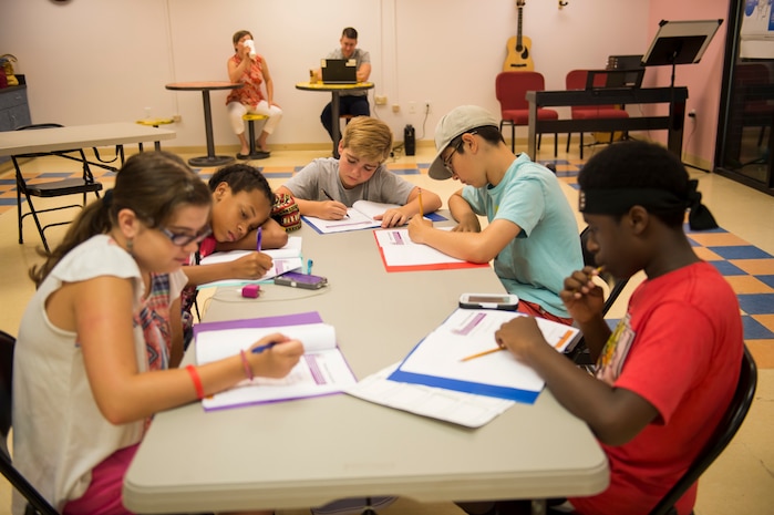 Participants of the first Air Force resiliency teen camp, named BOUNCE, write in their folders July 14, 2016 at Joint Base Charleston – Weapons station, S.C., youth center. BOUNCE, which stands for Be optimistic, Observe thoughts, Use strengths, Never give up, Communicate effectively and Embrace you, is a week-long camp designed to teach teens the necessary skills to overcome daily stressors associated to military families. (U.S. Air Force photo/Staff Sgt. Jared Trimarchi)