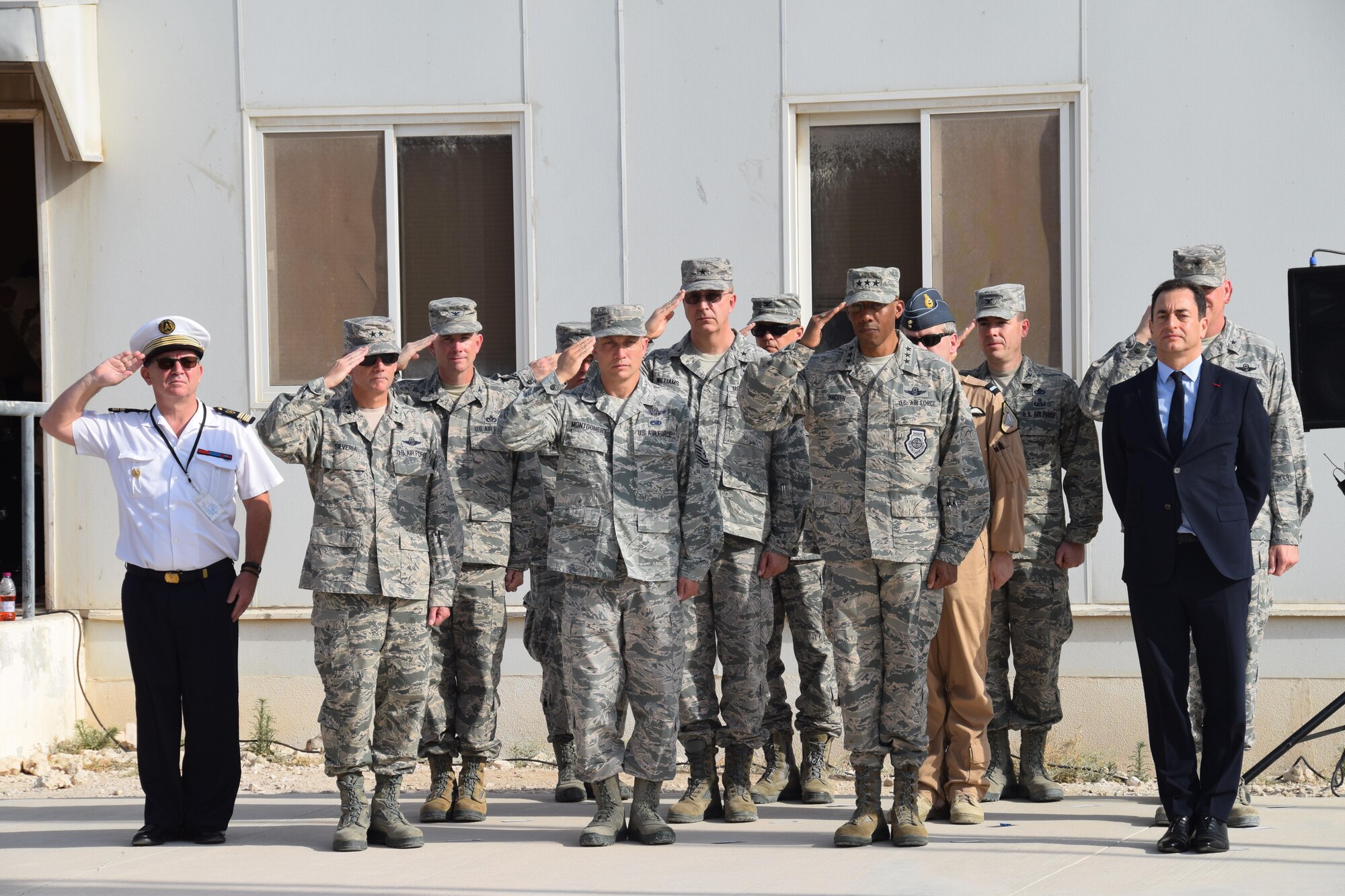 Coalition military members salute  during the raising of the French flag, known as the Tricolour, during the Bastille Day ceremony July 14, 2016, at Al Udeid Air Base, Qatar. France is one of 20 nations supporting the air Coalition that provides decisive air and space power to combat Daesh and other terrorist organizations and ensure the stability of the Southwest Asia region. (U.S. Air Force photo/Technical Sgt. Carlos J. Treviño/Released)