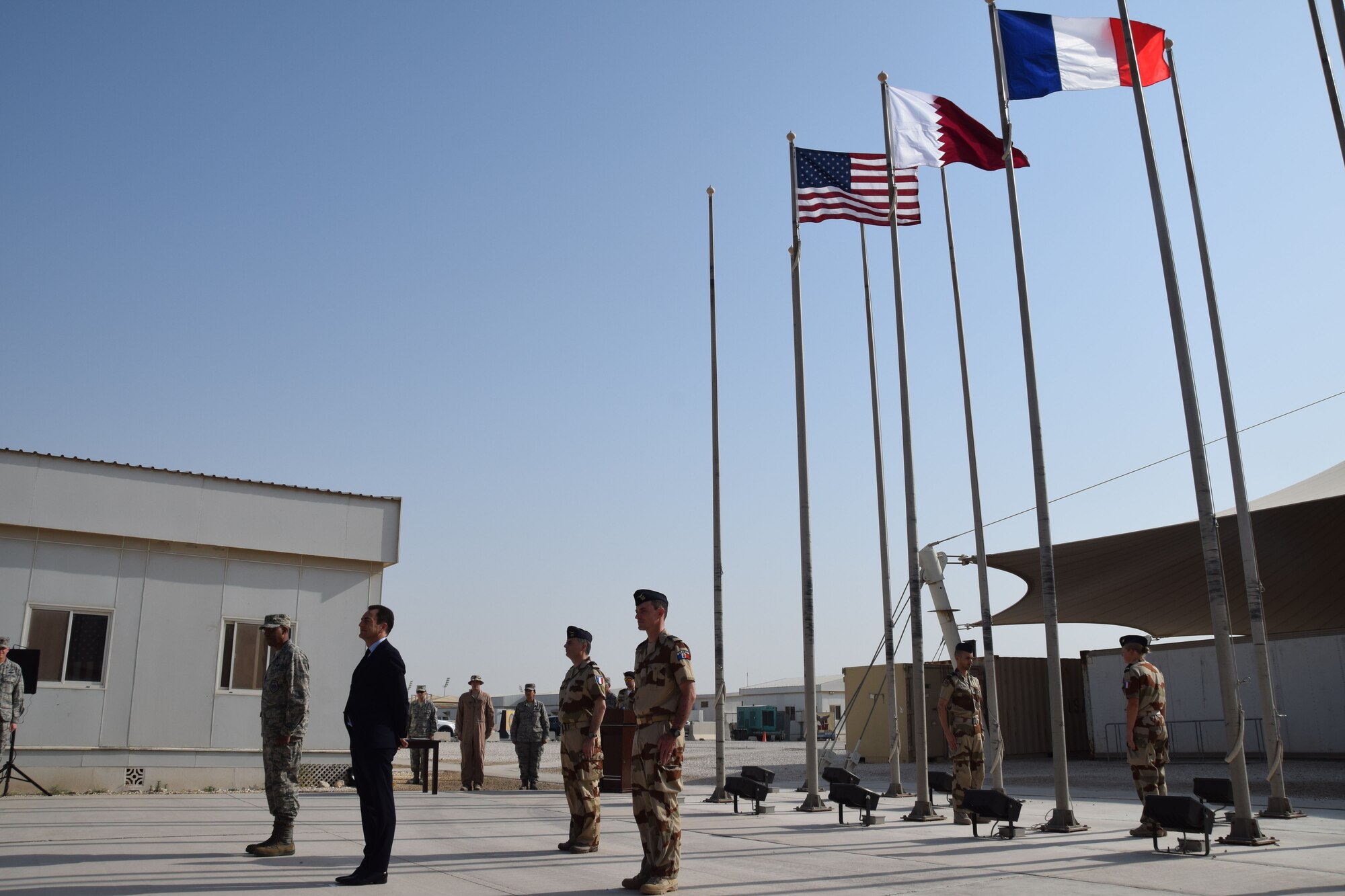 The French national flag, known as the Tricolour, is raised during the Bastille Day ceremony July 14, 2016, at Al Udeid Air Base, Qatar. Lt. Gen. Charles Brown, U.S. Air Forces Central Command commander, and Monsieur Eric Chevallier, Ambassador of France to Qatar, awarded the Air Force Achievement Medal and  French National Defense Medal to French and American military members who have participated in operational activities against Daesh and other terrorist organizations. (U.S. Air Force photo/Technical Sgt. Carlos J. Treviño/Released)

