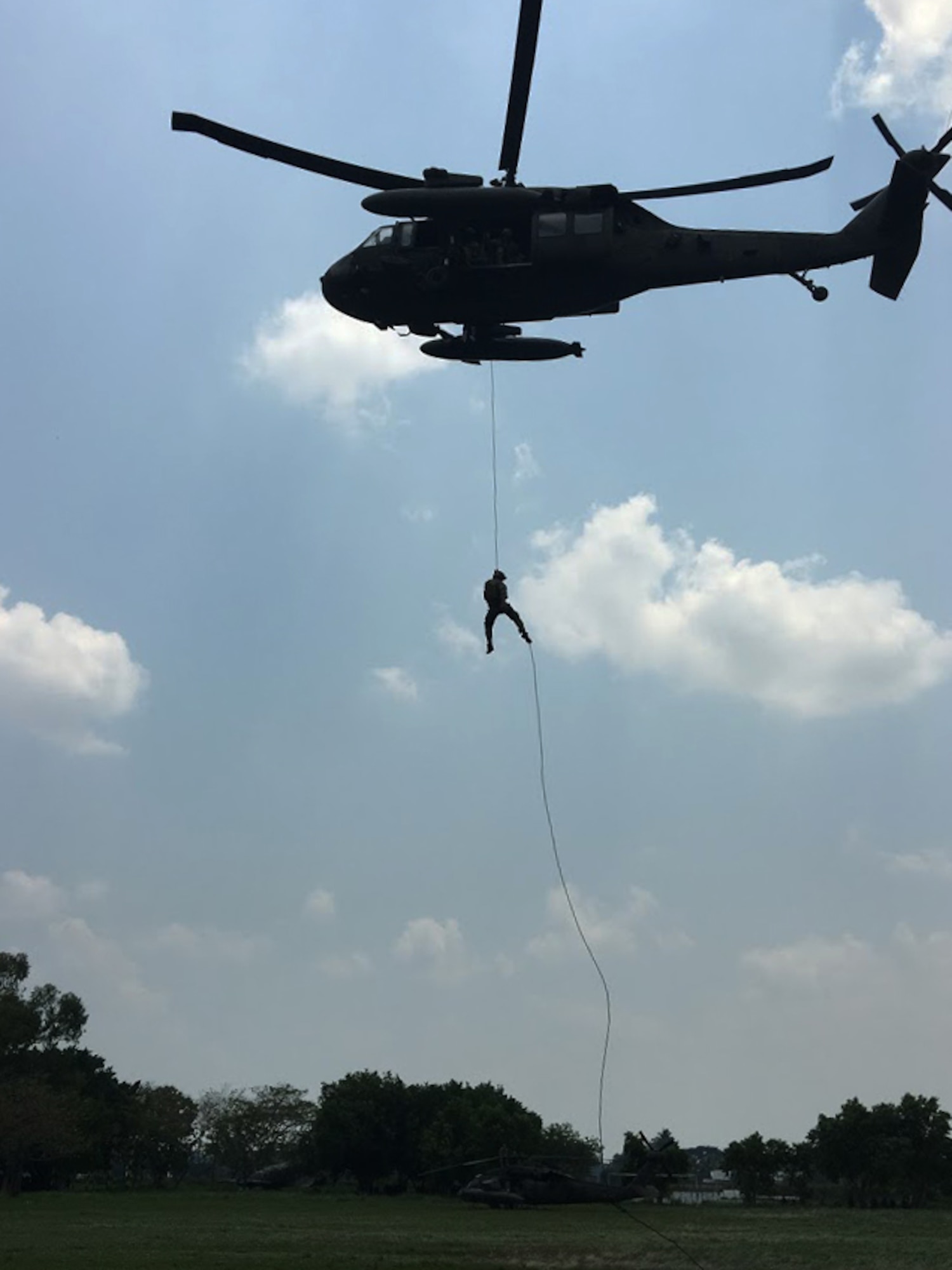 Members of the 1st Battalion, 228th Aviation Regiment from Joint Task Force-Bravo and Special Operations Command South conduct Fast Rope Insertion and Extraction System training from a UH-60 Black Hawk helicopter with Salvadorian military May 24 in El Salvador. JTF-Bravo and other U.S. Military elements, under the auspices of U.S. Southern Command, routinely conduct combined training and exercises with Partner Nation security forces in multiple Central American nations, improving the safety and security in the CENTAM region and southern approaches to the United States. According USSOUTHCOM officials, Salvadorian forces exemplify the command’s security cooperation objectives to enhance the capability of partners to operate successfully in contingency, peacekeeping, humanitarian, disaster and stability operations. (Courtesy Photo)