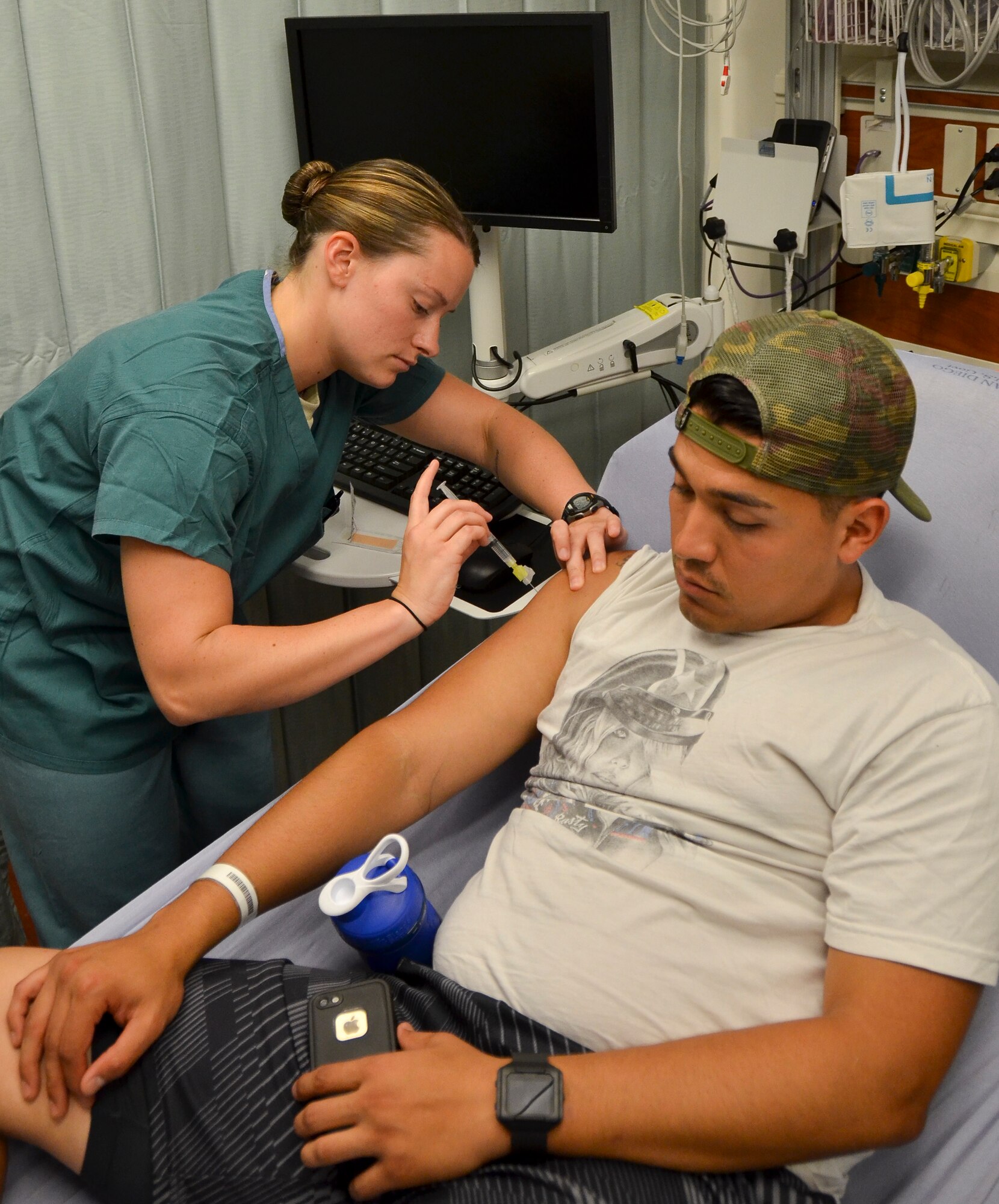 Staff Sgt. Sydney Bullock, medical technician, 117th Medical Group, administers a shot to a patient in Naval Medical Center San Diego, in San Diego, Calif., June 23, 2016.  The 117 MDG trained with the U.S. Navy at Naval Medical Center San Diego.  The training included Airmen being implemented in real world U.S. Naval operations.  (U.S. Air National Guard photo by Staff Sgt. Jeremy Farson/Released)   