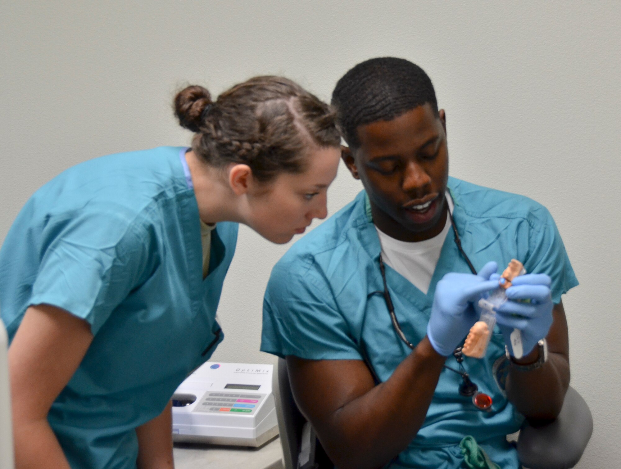 Lt. Webster K. Felix (right), general dentist, Naval Branch Health Clinic, Naval Base San Diego and Airman 1st Class Chayce Shelton, dental technician, 117th Medical Group, discuss a dental procedure in San Diego, Calif., June 23, 2016.  The 117 MDG trained with the U.S. Navy at Naval Medical Center San Diego.  The training included Airmen being implemented in real world U.S. Naval operations.  (U.S. Air National Guard photo by Staff Sgt. Jeremy Farson/Released)   