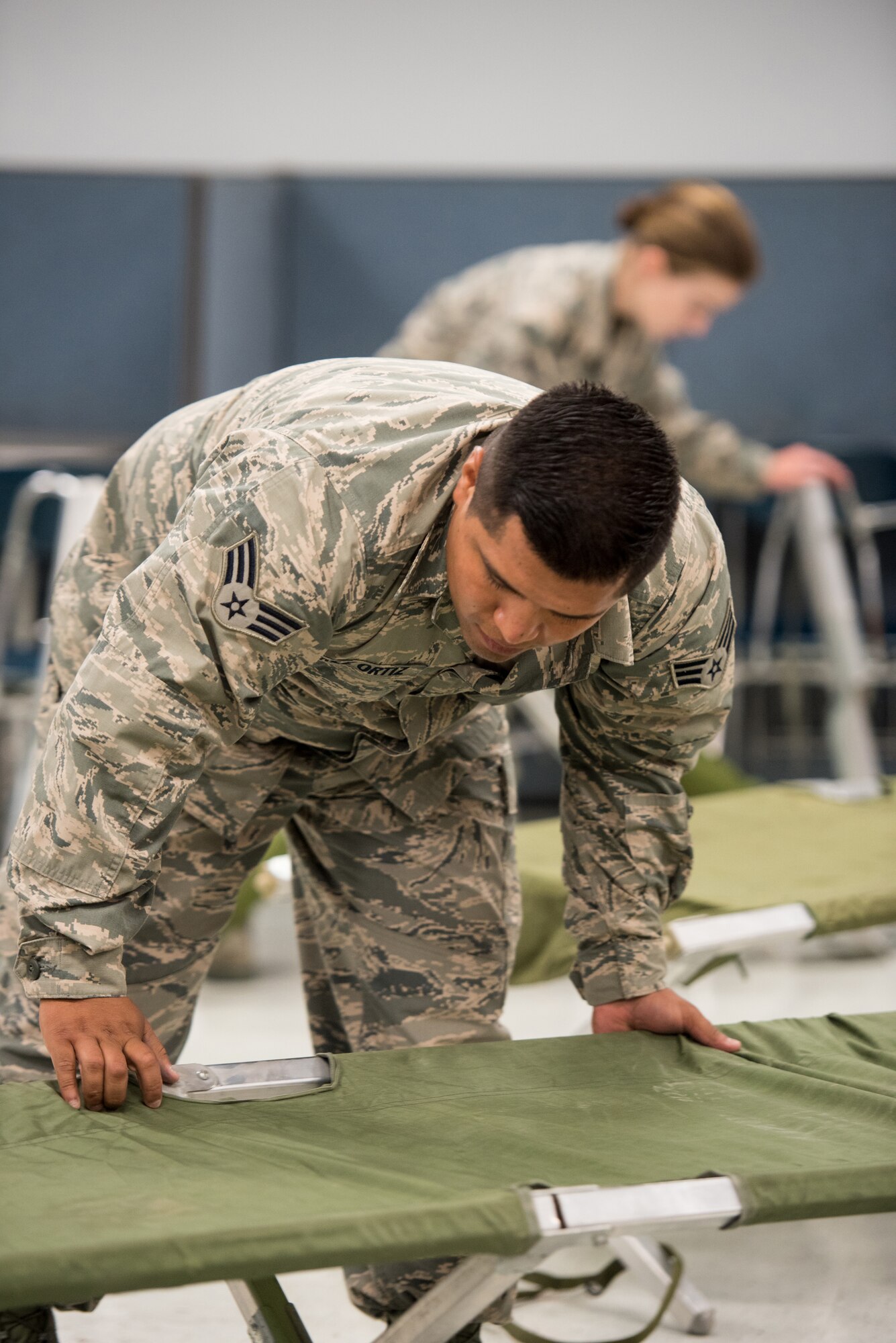 Senior Airman Nanstacio Perez-Ortiz, a food services specialist for the New Jersey Air National Guard's 108th Force Support Squadron, sets up cots for incoming military members at Graves County High School in Mayfield, Ky., July 15, 2016, in preparation for Bluegrass Medical Innovative Readiness Training. The program will offer medical and dental care at no cost to residents in three Western Kentucky locations from July 18 to 27. (U.S. Air National Guard photo by Master Sgt. Phil Speck)