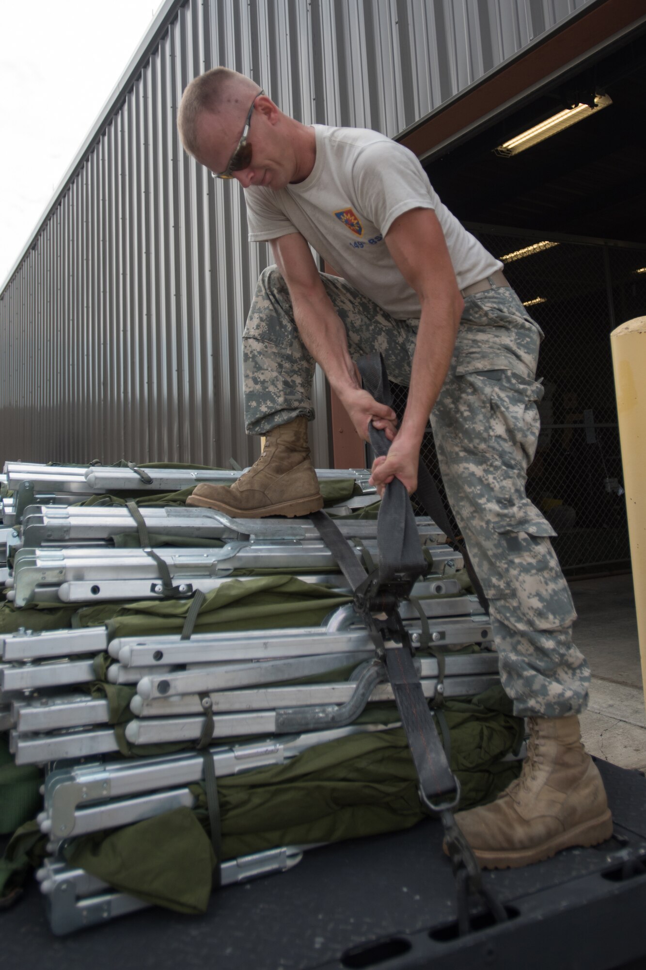 Sgt. Joseph Foriest, a transportation specialist for the Kentucky Army National Guard’s 149th Brigade Support Battalion, tightens down straps across cots at Barkley Regional Airport in Paducah, Ky., July 14, 2016, in preparation for Bluegrass Medical Innovative Readiness Training. The program will offer medical and dental care at no cost to residents in three Western Kentucky locations from July 18 to 27. (U.S. Air National Guard photo by Master Sgt. Phil Speck)