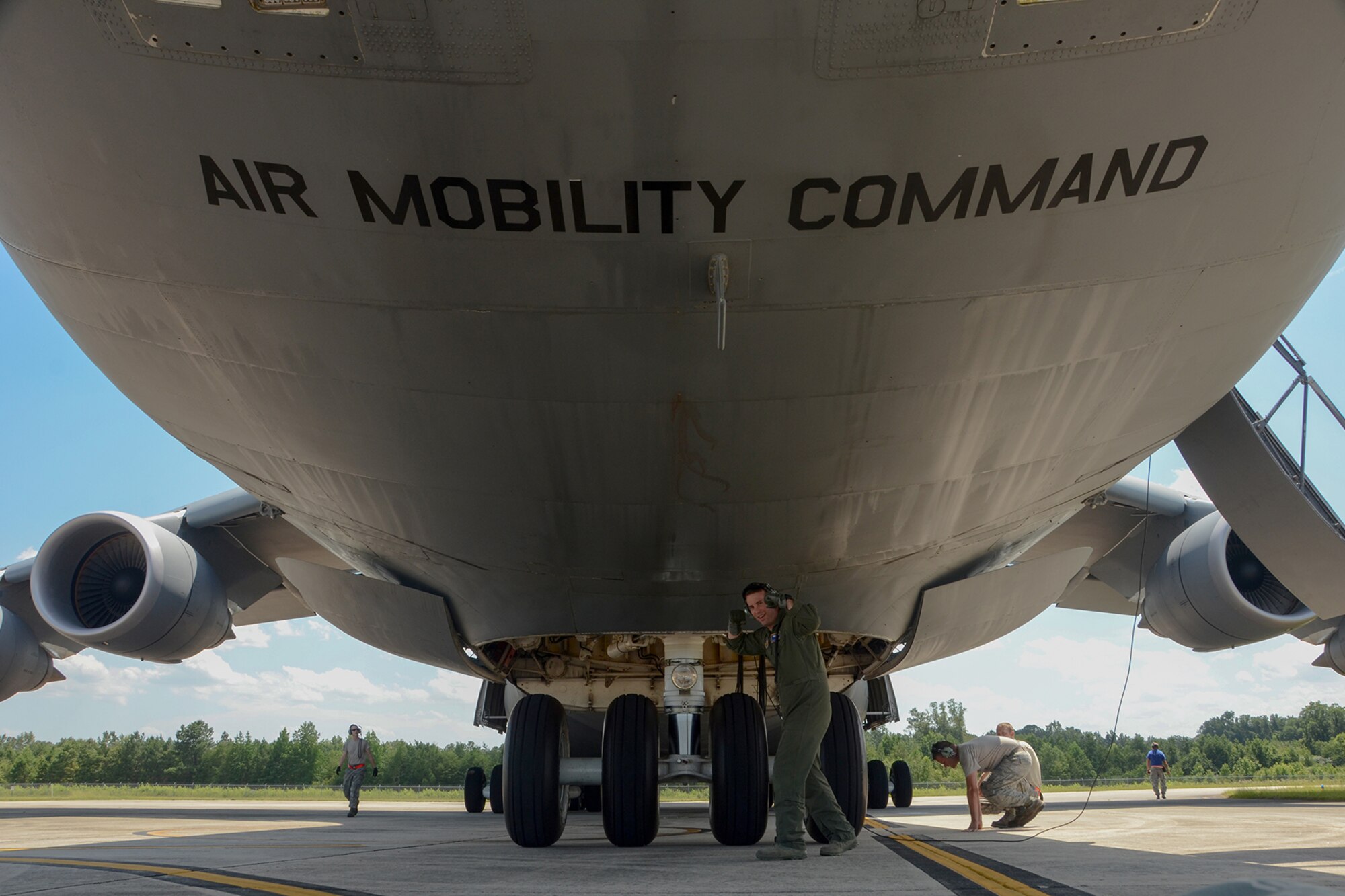 U.S. Air Force Tech. Sgt. Jake Schlemmer, a flight engineer assigned to the 709th Airlift Squadron, poses under a U.S. Air Force Lockheed C-5 Galaxy transport aircraft at McEntire Joint National Guard Base, S.C., July 8, 2016. Approximately 300 U.S. Airmen and 12 F-16 Fighting Falcon jets from the 169th Fighter Wing at McEntire JNGB, S.C., are deploying to Osan Air Base, Republic of Korea, as the 157th Expeditionary Fighter Squadron in support of the U.S. Pacific Command Theater Security Package. (U.S. Air National Guard photo by Airman 1st Class Megan Floyd)