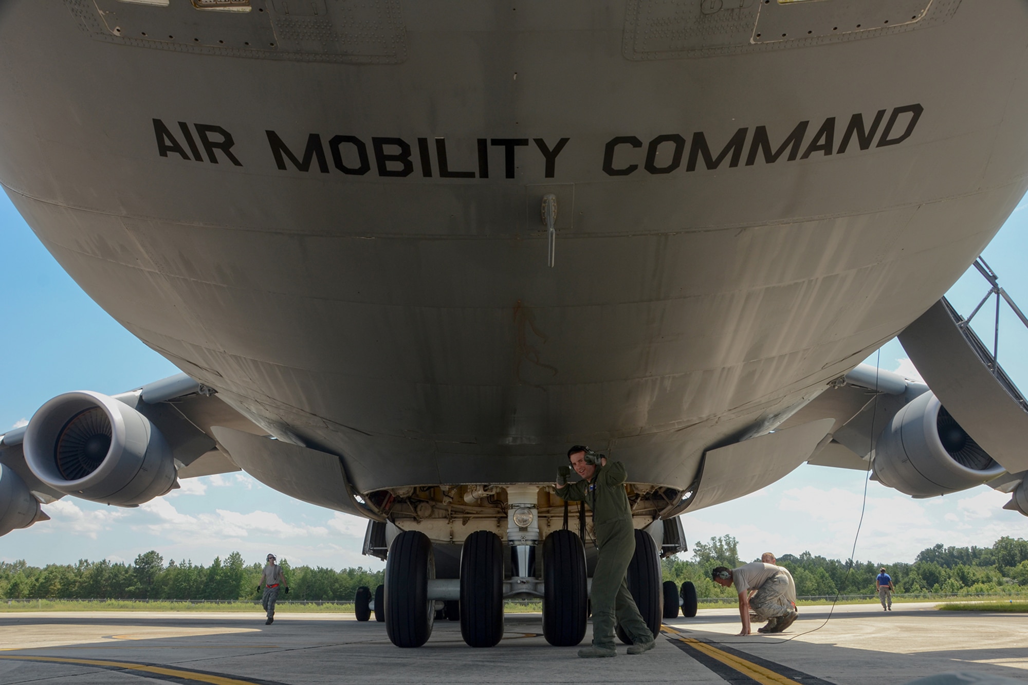 U.S. Air Force Tech. Sgt. Jake Schlemmer, a flight engineer assigned to the 709th Airlift Squadron, poses under a U.S. Air Force Lockheed C-5 Galaxy transport aircraft at McEntire Joint National Guard Base, S.C., July 8, 2016. Approximately 300 U.S. Airmen and 12 F-16 Fighting Falcon jets from the 169th Fighter Wing at McEntire JNGB, S.C., are deploying to Osan Air Base, Republic of Korea, as the 157th Expeditionary Fighter Squadron in support of the U.S. Pacific Command Theater Security Package. (U.S. Air National Guard photo by Airman 1st Class Megan Floyd)