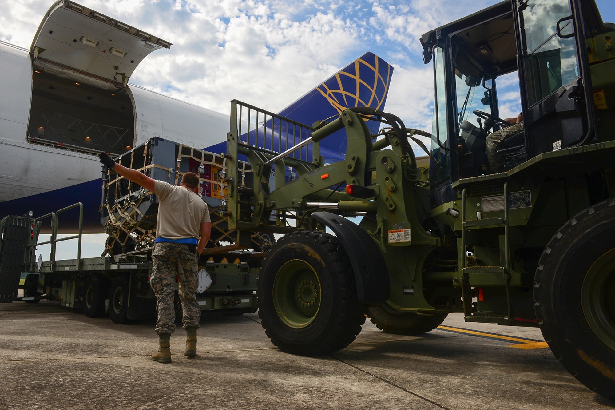 U.S. Air Force Tech. Sgt. Josh Williams, an air transportation specialist assigned to the 169th Logistics Readiness Squadron, guides a forklift carrying cargo at McEntire Joint National Guard Base, S.C., July 8, 2016. Approximately 300 U.S. Airmen and 12 F-16 Fighting Falcon jets from the 169th Fighter Wing at McEntire JNGB, S.C., are deploying to Osan Air Base, Republic of Korea, as the 157th Expeditionary Fighter Squadron in support of the U.S. Pacific Command Theater Security Package. (U.S. Air National Guard photo by Airman 1st Class Megan Floyd)
