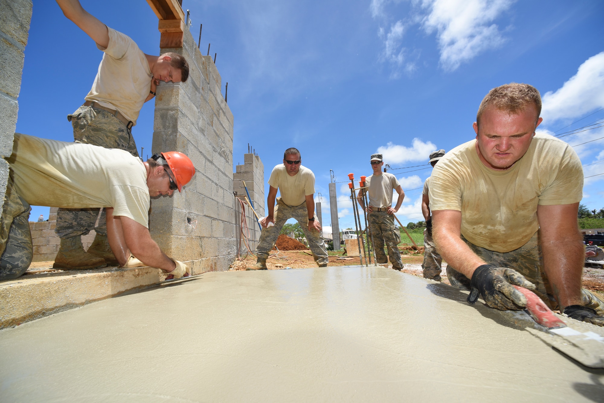 Maj. Jody W. Page, 114th Civil Engineer Squadron commander, oversees Airmen screeding a front porch concrete slab during the third phase of a multi project house build for Habitat for Humanity of Guam(HFHG), Inarajan, July 14, 2016. Airmen from the 114th Fighter Wing deployed to the Island of Guam to gain real world construction training as they assisted HFHG on the construction of two single family homes. (U.S. Air National Guard photo by Staff Sgt. Luke Olson/Released)