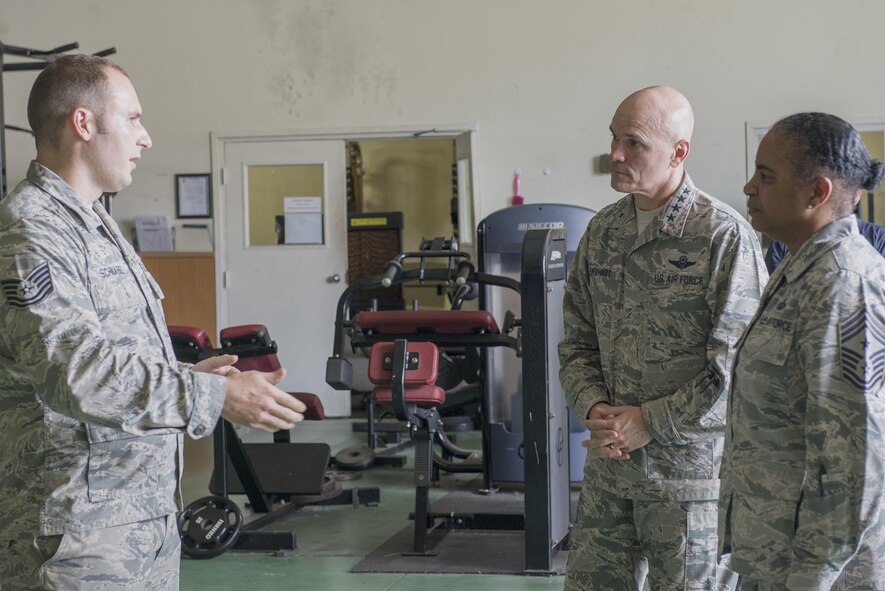 Gen. Carlton Everhart, Air Mobility Command commander, and Chief Master Sgt. Shelina Frey, AMC command chief, are briefed by Tech. Sgt. David Schnabel, 730th Air Mobility Squadron quality assurance chief inspector, at Yokota Air Base, Japan, July 10, 2016. Schnabel highlighted the tenant unit's training and joint efforts with the host wing during the tour. (U.S. Air Force photo by Senior Airman David C. Danford/Released)