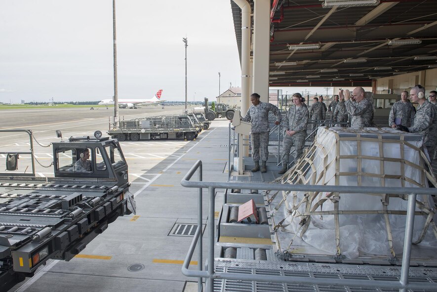 Gen. Carlton Everhart, Air Mobility Command commander, and Chief Master Sgt. Shelina Frey, AMC command chief, load a pallet onto a 60k Tunner at Yokota Air Base, Japan, July 10, 2016. Everhart took part in an interactive tour of the 730th Air Mobility Squadron facilities as part of his 515th Air Mobility Operations Wing Pacific visit. (U.S. Air Force photo by Senior Airman David C. Danford/Released)