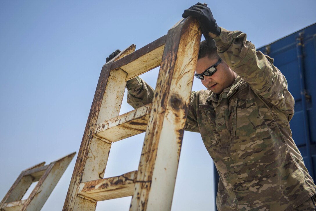 Air Force Staff Sgt. Jacob Chavez places a vehicle ramp on a truck at Bagram Airfield, Afghanistan, July 14, 2016. Chavez is a material recovery specialist assigned to the 455th Expeditionary Logistics Readiness Squadron Central Command. Air Force photo by Senior Airman Justyn M. Freeman