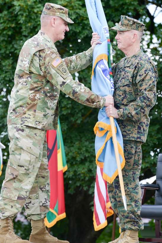 Army Gen. David M. Rodriguez, outgoing commander of U.S. Africa Command, passes the U.S. Africa Command flag to Marine Corps Gen. Joe Dunford, chairman of the Joint Chiefs of Staff, during the change-of-command ceremony at U.S. Army Garrison Stuttgart, Germany, July 18, 2016. DoD photo by Jason Johnston
