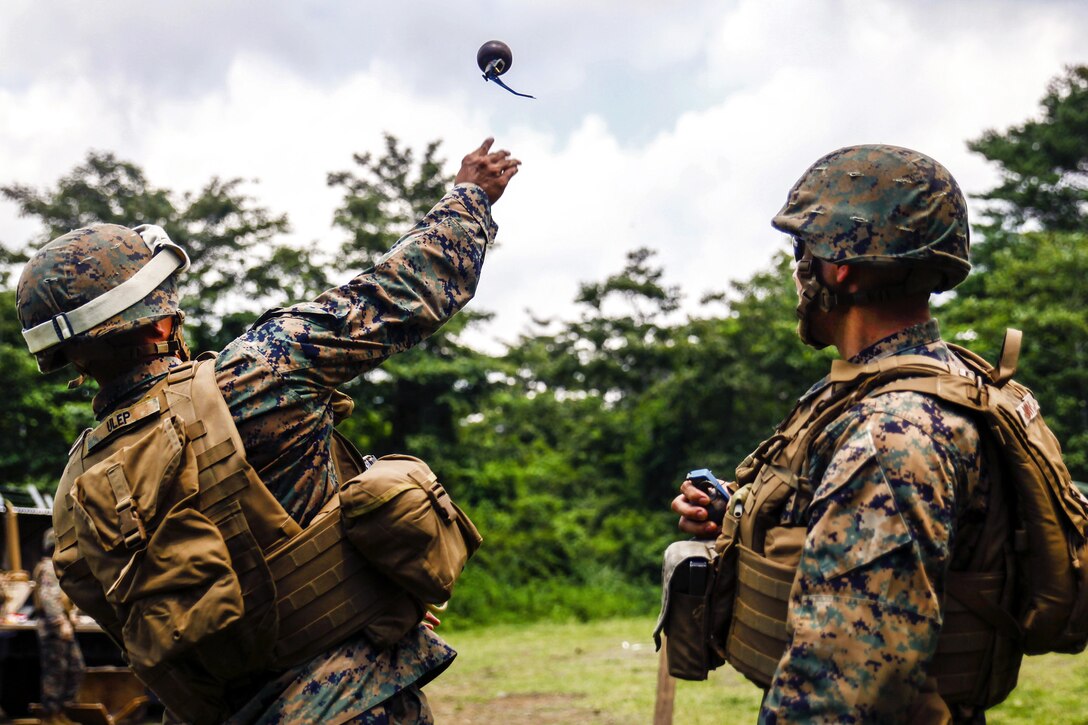 Marine Corps Lance Cpl. Jordan Ulep, left, throws an M69 practice grenade during Exercise Eagle Wrath 2016 at Combined Arms Training Center Camp Fuji, Japan, July 11, 2016. Ulep is a heavy equipment operator assigned to Marine Wing Support Squadron 171. Marine Corps photo by Lance Cpl. Aaron Henson