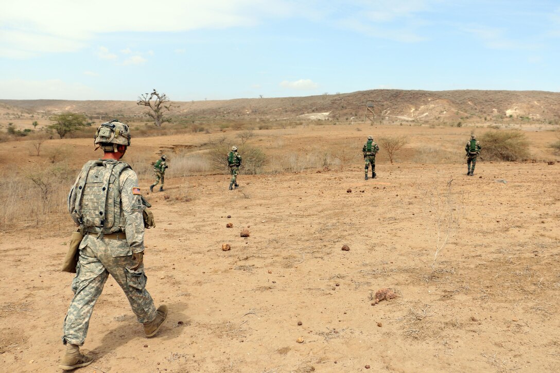 An Army infantryman, left, observes Senegalese soldiers with the 1st Paratrooper Battalion move toward their objective during a squad-level exercise as part of Africa Readiness Training 16 in Thies, Senegal, July 14, 2016. Army photo by Staff Sgt. Candace Mundt