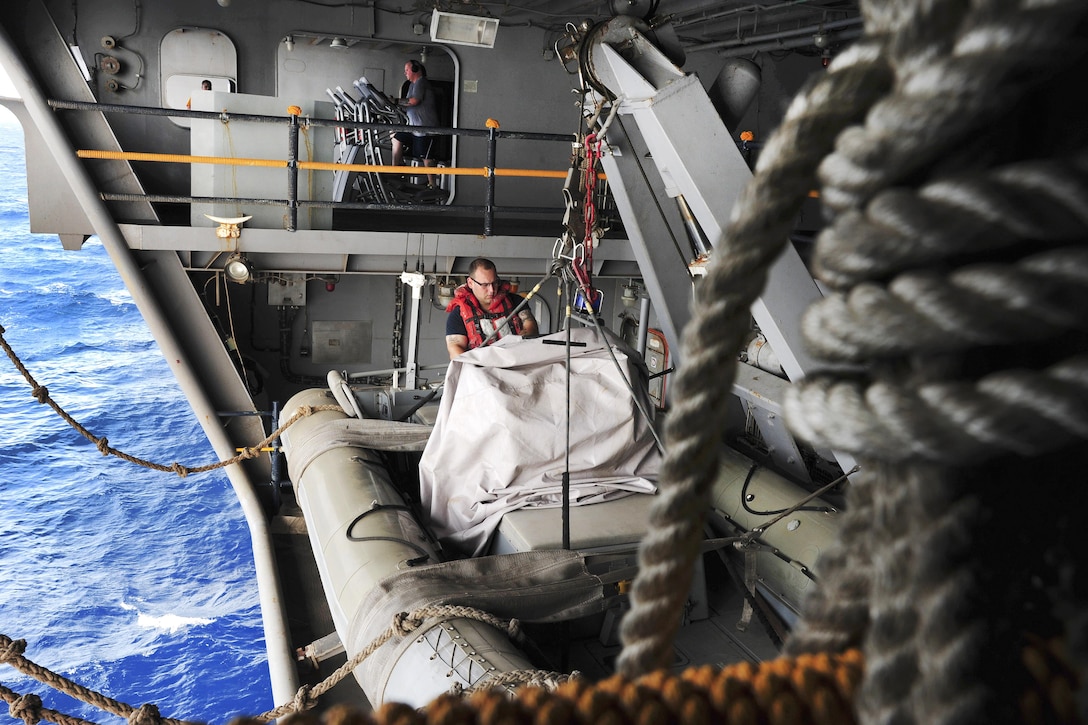 Navy Seaman Chase Correa logs a report of the starboard rigid-hull inflatable boat aboard the aircraft carrier USS Dwight D. Eisenhower in the Gulf of Aden, July 16, 2016. Navy photo by Seaman Dartez C. Williams