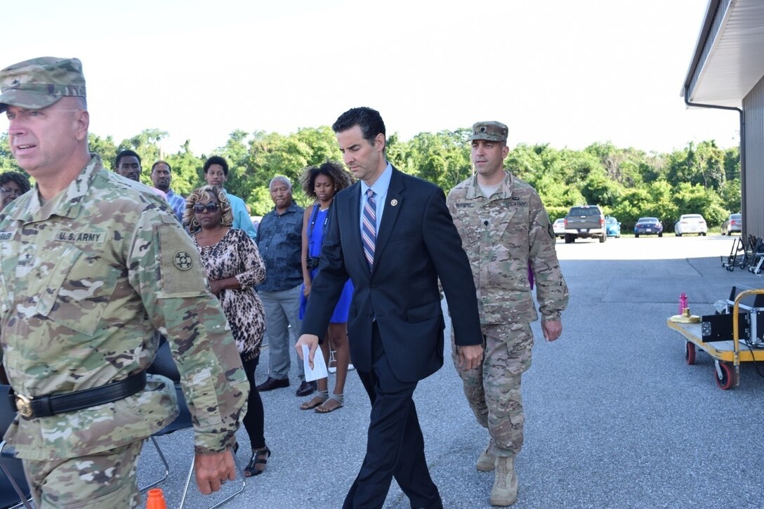 Army Reserve Brig. Gen. Vincent B. Barker, commanding general of the 310th Sustainment Command (Expeditionary) (left), U.S. Representative John Sarbanes, 3rd District, Maryland (center), and Lt. Col. Christopher J. Buzard, commander of the 313th Movement Control Battalion (right), walk to the podium during a ceremony to case the unit colors in preparation for deployment on July 10, 2016, in Baltimore, Md., at the 1SG Adam S. Brandt United States Army Reserve Center. The 313th MCB is scheduled to deploy to the Middle East in support of Operation Enduring Freedom.