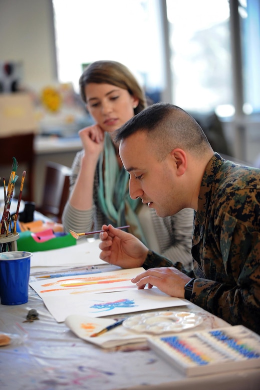 Marine Corps Staff Sgt. Anthony Mannino performs art therapy with guidance from Adrienne Stamper, art therapy intern as part of his traumatic brain injury treatment and recovery at the National Intrepid Center of Excellence in Bethesda, Md., March 1, 2016. DoD photo by Marvin Lynchard