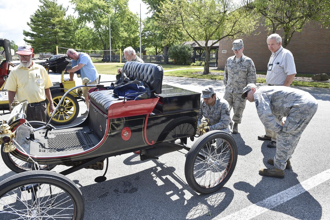 910th Airlift Wing members Tech. Sgt. Florin Gargarita, Senior Airman Timothy McCarthy and Master Sgt. Nathan Moffitt, all from the 910th Maintenance Squadron, view the running engine of a restored 1902 Oldsmobile car here, July 15, 2016. Veteran Motor Car Club of America (VMCCA) member and automobile owner Dave Tansey stands by to answer the questions. VMCCA members brought approximately 15 vehicles and 35 guests to tour the installation and stayed afterward to provide 910th members a viewing of their vehicles. Their cars are all restored one and two cylinder functioning historic vehicles from the early 1900s. (U.S. Air Force photo/Eric White)