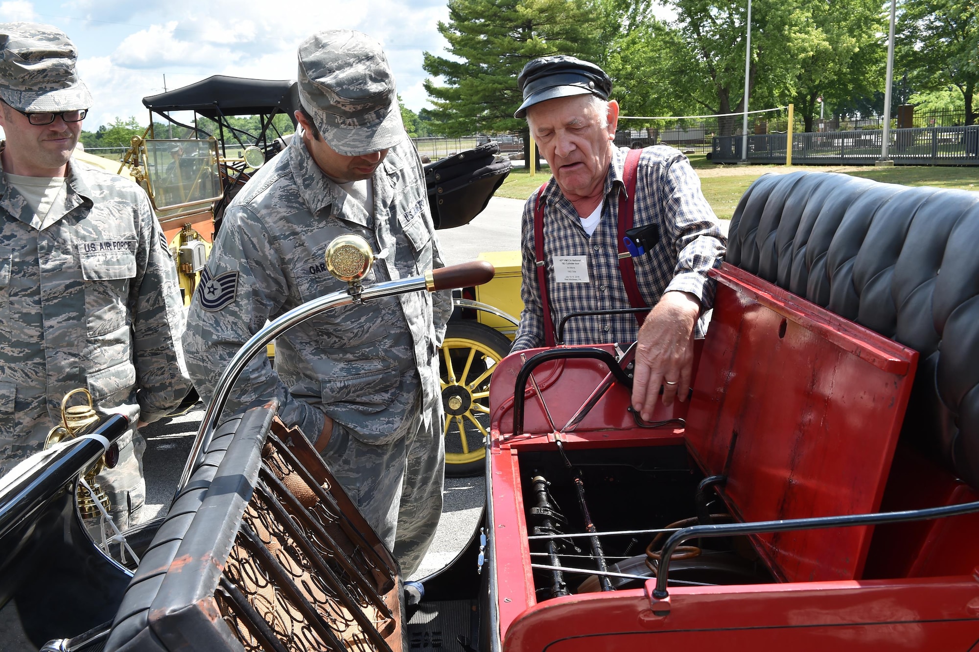 Art Morra, owner of a 1902 Oldsmobile and Veteran Motor Car Club of America (VMCCA) member, explains the engine of his historic vehicle during an installation tour here, July 15, 2016. Senior Airman Timothy McCarthy and Tech. Sgt. Florin Gargarita, both from the 910th Maintenance Squadron, observe. VMCCA members brought approximately 15 vehicles and 35 guests to tour the installation and stayed afterward to provide 910th members a viewing of their vehicles. Their cars are all restored one and two cylinder functioning historic vehicles from the early 1900s. (U.S. Air Force photo/Eric White)