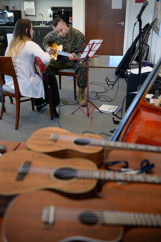 Marine Corps Staff Sgt. Anthony Mannino plays guitar as part of his traumatic brain injury treatment and recovery, with guidance form music therapy intern Kalli Jermyn at the National Intrepid Center of Excellence in Bethesda, Md., March 1, 2016. DoD photo by Marvin Lynchard