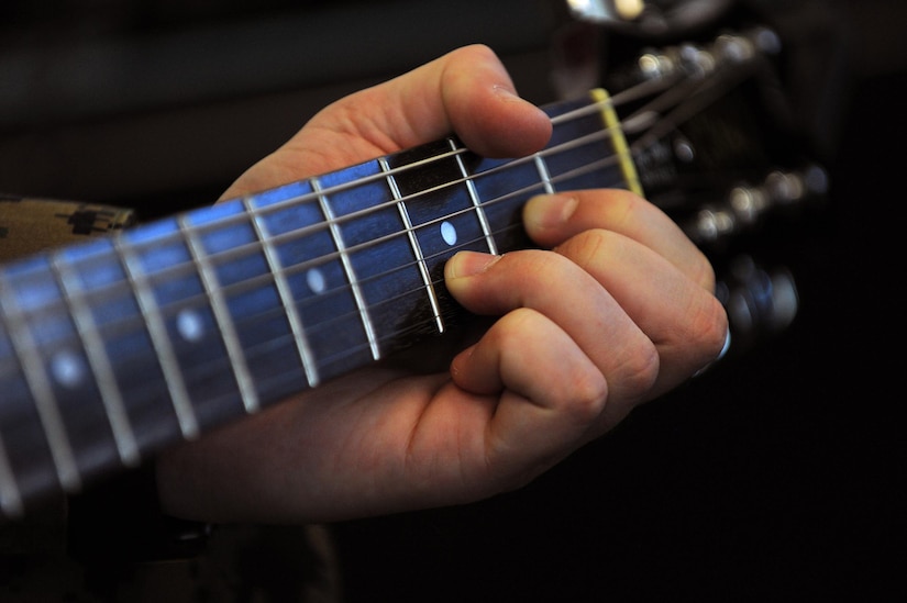 Marine Corps Staff Sgt. Anthony Mannino forms a D chord on the guitar as part of his traumatic brain injury treatment and recovery at the National Intrepid Center of Excellence in Bethesda, Md., March 1, 2016. DoD photo by Marvin Lynchard