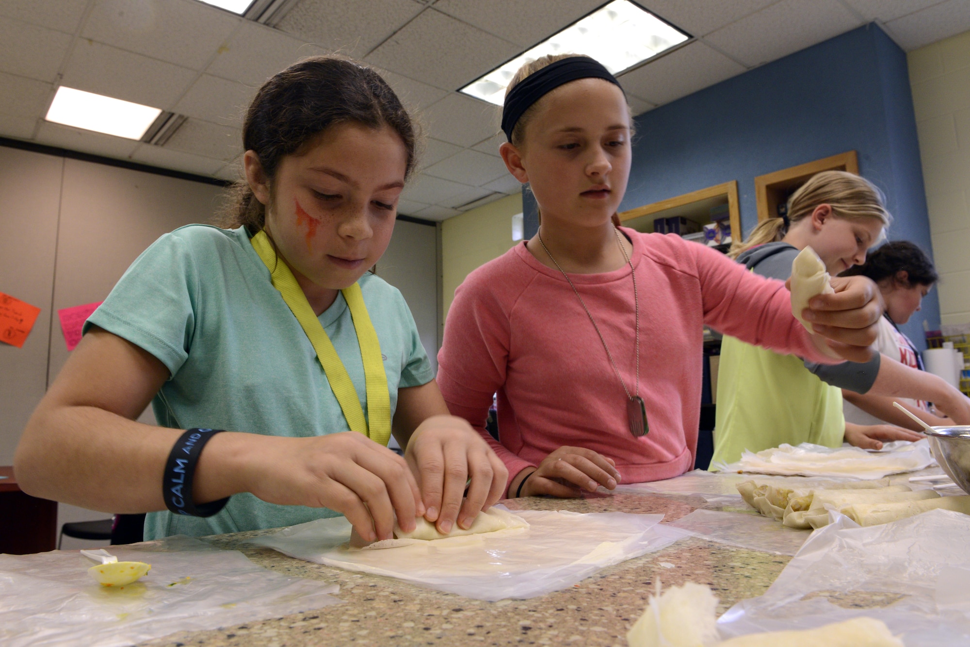 Isabella Yockman, 10, and Savanna Richter, 10, wrap egg rolls at the Two Rivers Cooking Camp hosted at Two Rivers Youth Center, Joint Base Elmendorf-Richardson, Alaska, July 11, 2016. Outside of the cooking camp, cooking classes are offered every Tuesday to Youth Center members. (U.S. Air Force photo by Airman 1st Class Javier Alvarez)