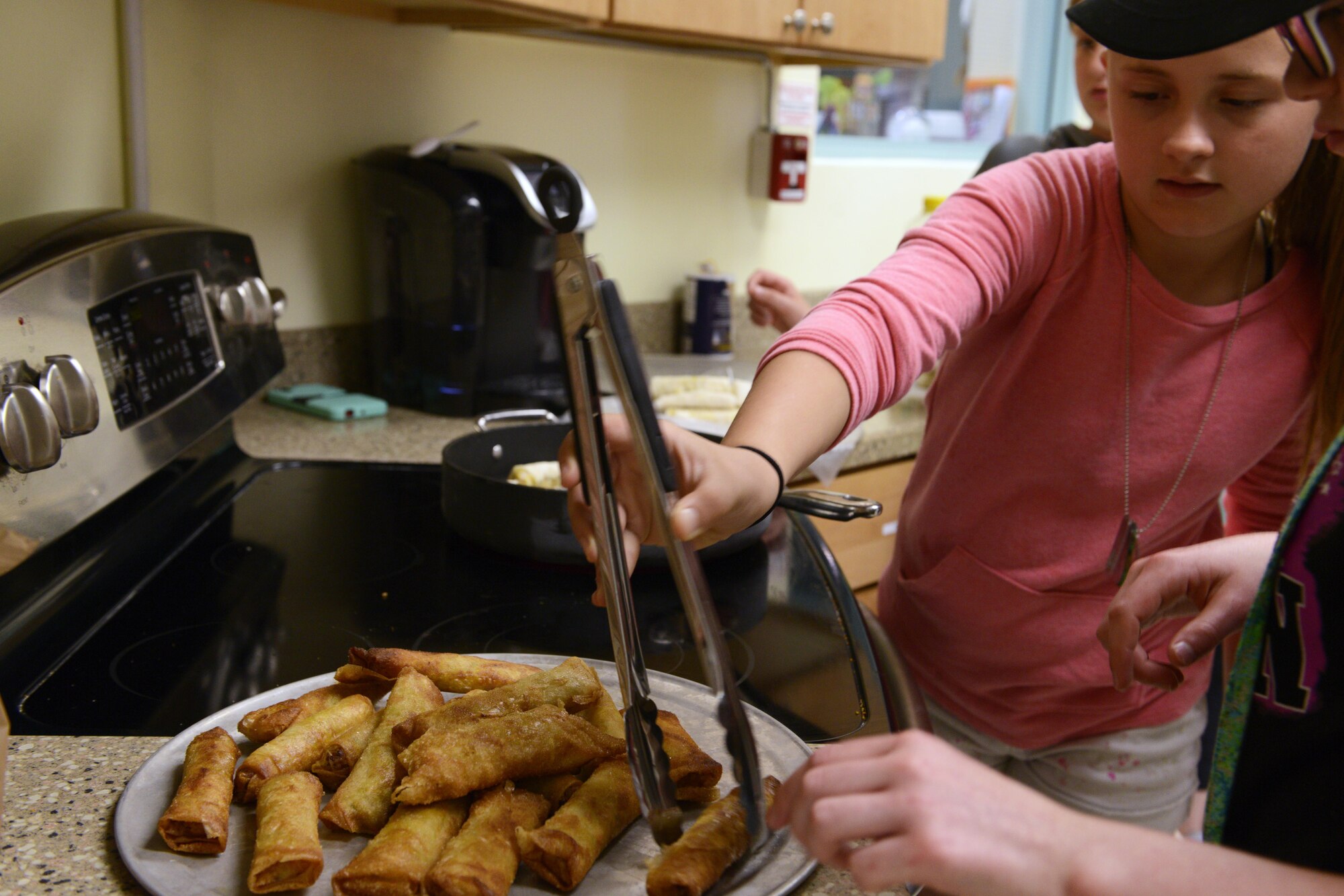 Savanna Richter, 10, carefully removes completed egg rolls from the frying oil at the Two Rivers Cooking Camp hosted at Two Rivers Youth Center, Joint Base Elmendorf-Richardson, Alaska, July 11, 2016. Cooking Camp participants took turns chopping, mincing, wrapping, frying, and eating egg rolls. (U.S. Air Force photo by Airman 1st Class Javier Alvarez)