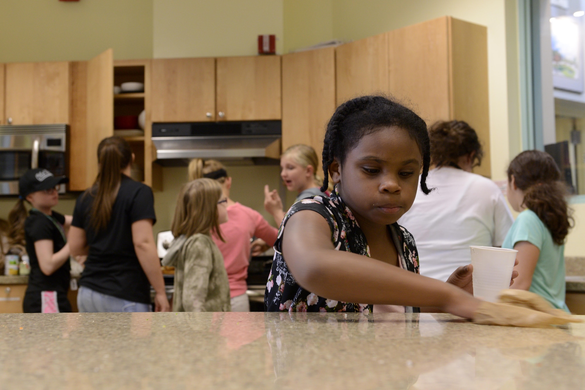 Amira Ball, 10, cleans off the counter top after rolling a mountain of egg rolls at the Two Rivers Cooking Camp hosted at Two Rivers Youth Center, Joint Base Elmendorf-Richardson, Alaska, July 11, 2016. Multiple camps are hosted by JBER youth centers during the summer months. (U.S. Air Force photo by Airman 1st Class Javier Alvarez)