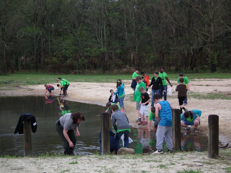 Park Ranger Angela Griffin assists the Sneads Elementary fourth graders as they collect tadpoles at the Every Kid in a Park fieldtrip at Lake Seminole