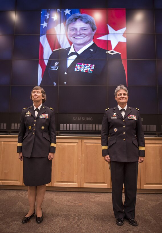 U.S. Army Reserve Brig. Gen. Janice M. Haigler (right), deputy commanding general of the 335th Signal Command (Theater), and Maj. Gen. Janet Lynn Cobb, commander of the 81st Regional Support Command, stand at attention under a large projection of Haigler's formal photo during her retirement ceremony at Fort Jackson, S.C., July 16, 2016. (U.S. Army photo by Staff Sgt. Ken Scar)